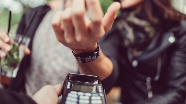 A woman pays contactless with her smartwatch