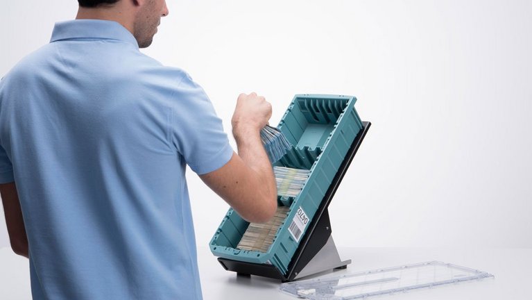 A man fills banknotes into a NotaTray®