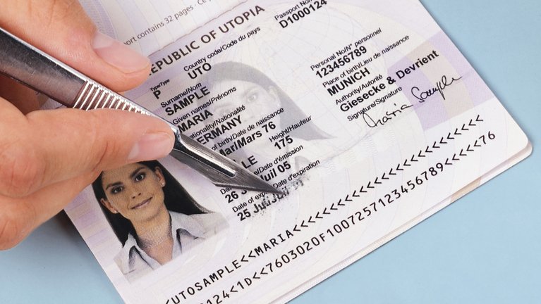 Someone tries to scratch the writing off an identity document with a sharp knife