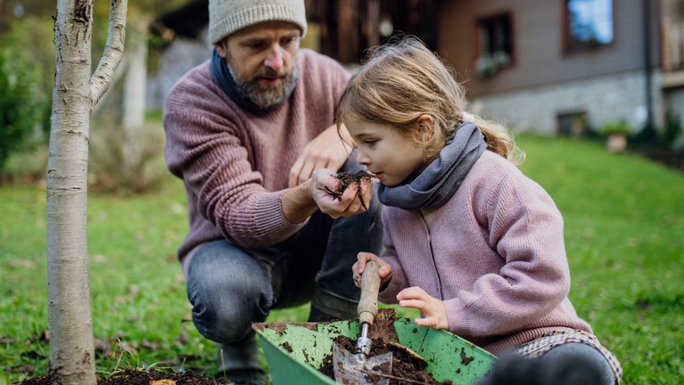 father and daughter planting a tree