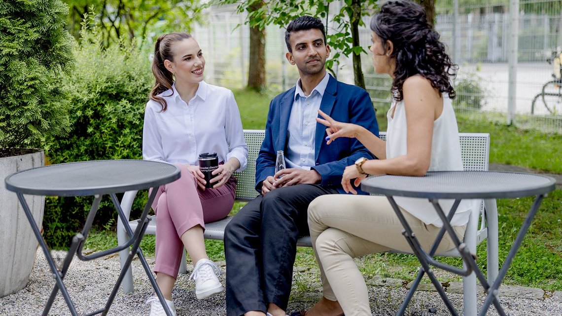 Three colleagues discussing in garden