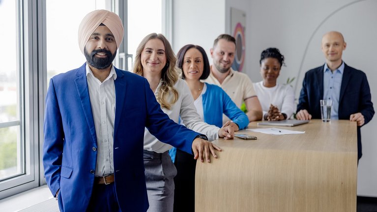 Team in a meeting room with laptop and documents