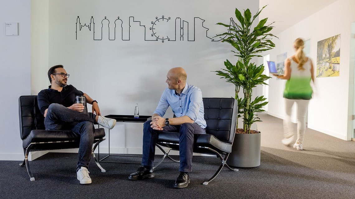 Two colleagues sitting and talking in an open office space