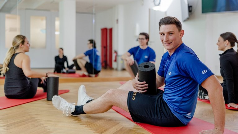 Group with blackrolls in the gym