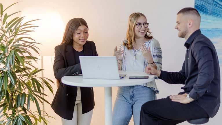 Teamwork in office with plants and laptop
