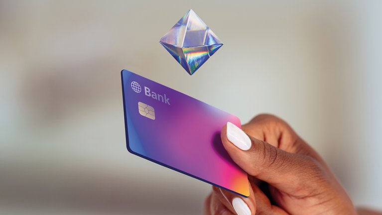 Hand holding a holographic bank card.