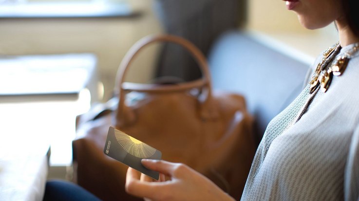 A woman holding her ceramic payment card in her hand