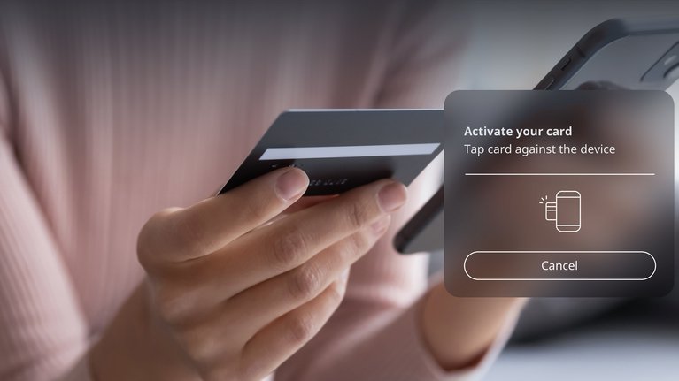 Person is holding their smartphone and payment card in their hand and is in the process of activating the payment card