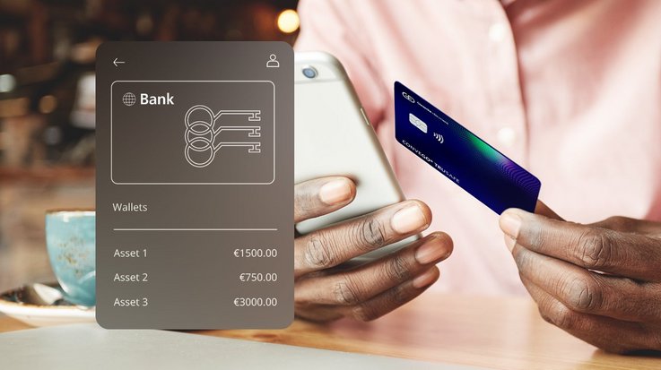 A person holding a smartphone displaying a bank application interface and a payment card