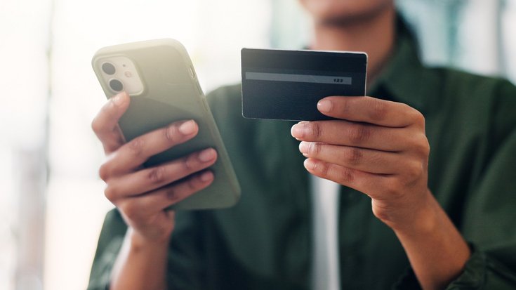 Person holding a smartphone and a credit card