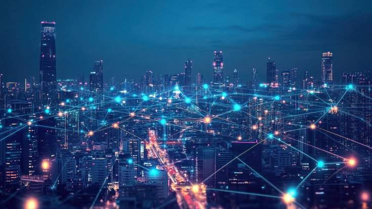 Connected city skyline at night with glowing network lines