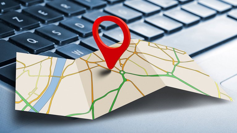 A map with a location pin placed on a keyboard