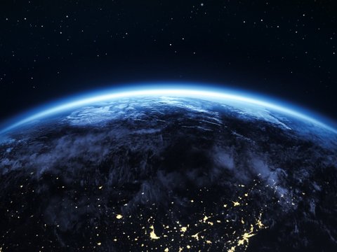 View of planet Earth from space with glowing atmosphere, illuminated lights, and a starry night sky