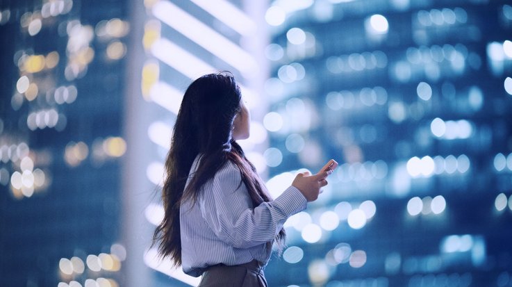 Women with mobile phone in urban surroundings