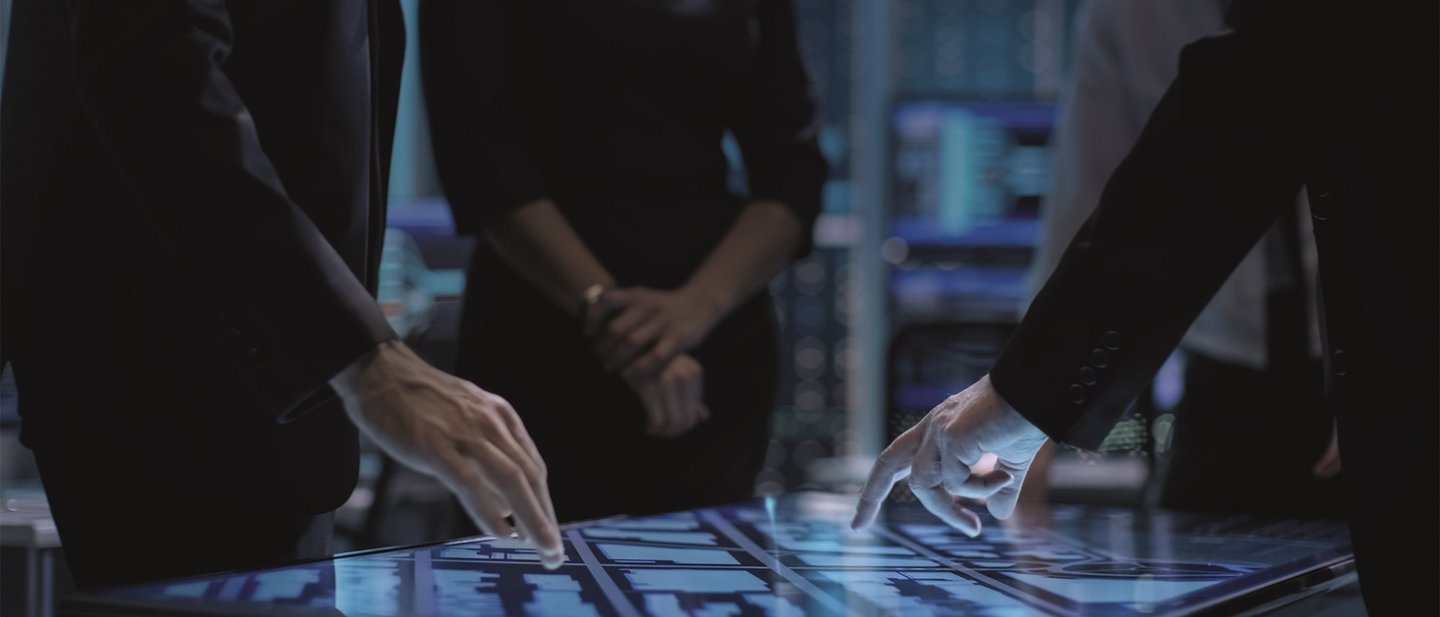 Hands of people pointing at a large touch screen