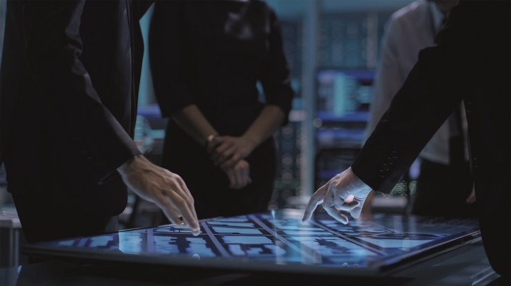 Hands of people pointing at a large touch screen