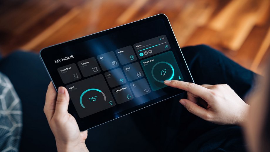 Woman controlling smart home functions like lighting and temperature using a tablet with an app.