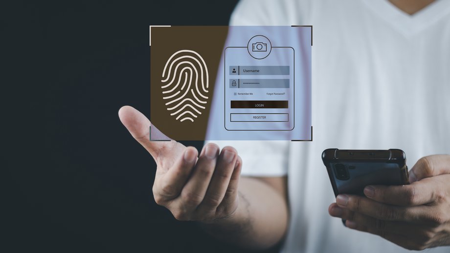 A person holding a smartphone and projecting a holographic interface for fingerprint and registration over their hand.