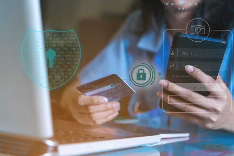 Person holding a smartphone and a credit card, digital security symbols.