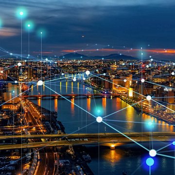 City skyline at night with illuminated network connections symbolizing digital communications
