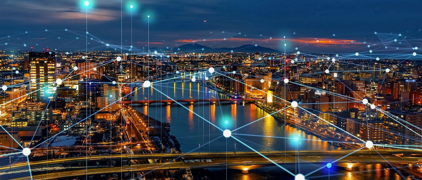 City skyline at night with illuminated network connections symbolizing digital communications