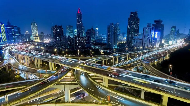 Rush hour traffic on multiple highways and flyovers at night illustrating connectivity.