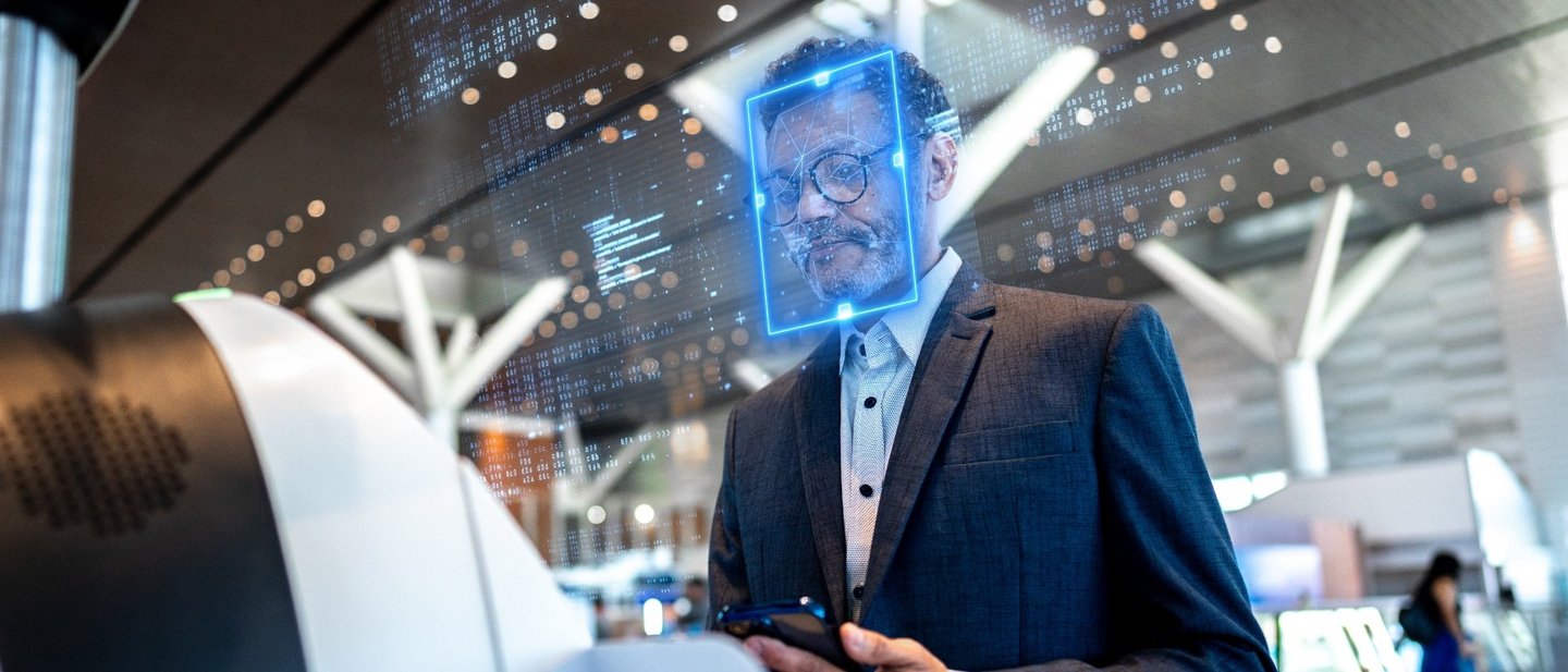 Ein Mann steht am Flughafen-Check-in mit Gesichtserkennung und testet so modernes Reisen.