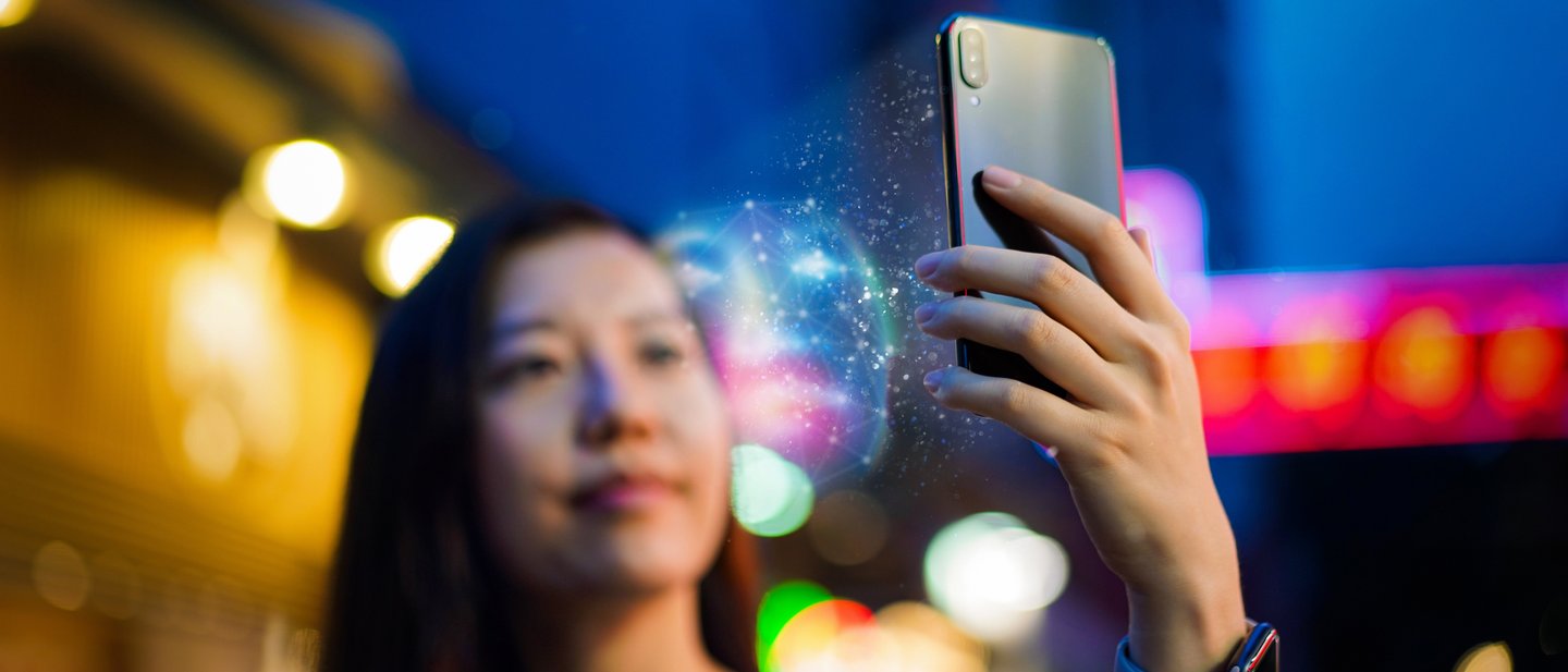 Person using a smartphone at a subway turnstile for contactless payment.