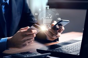 A man holding a smartphone in one hand and a payment card in the other, ready to make a digital transaction.