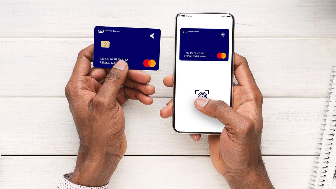 Man holding a physical payment card and phone displaying a digital payment card 