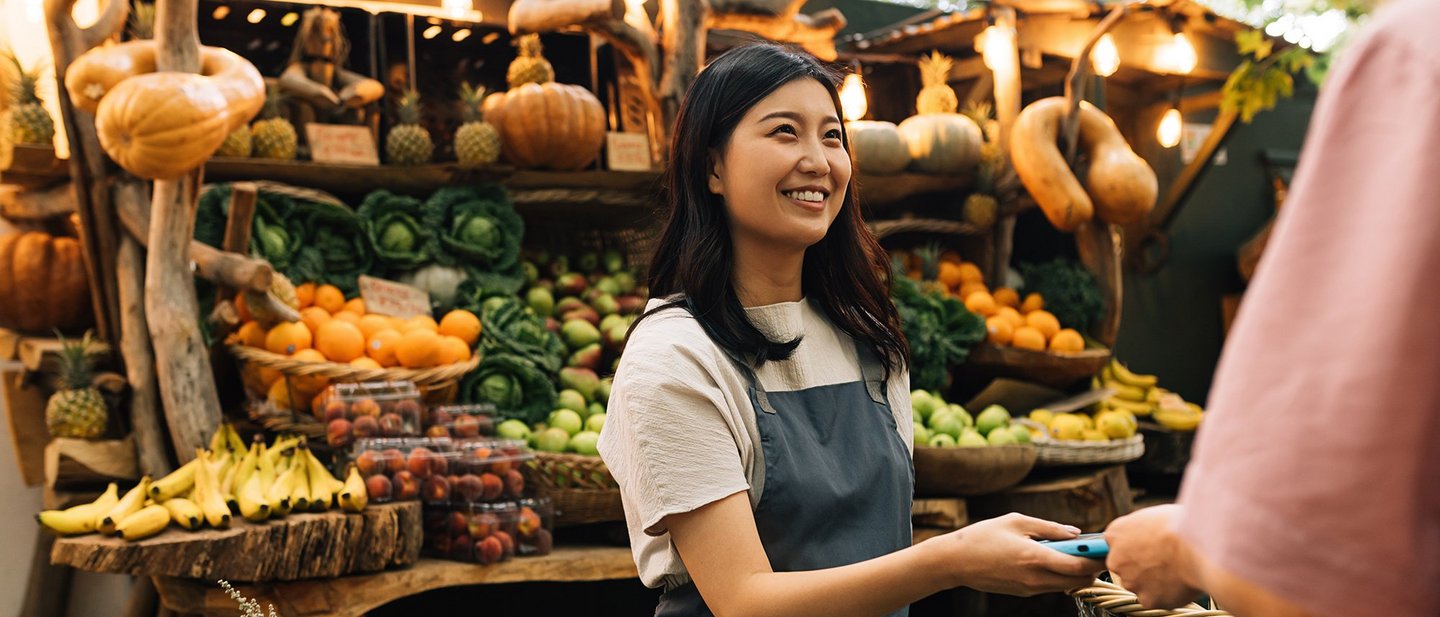 Female vendor receiving CBDC payment on the outdoor market