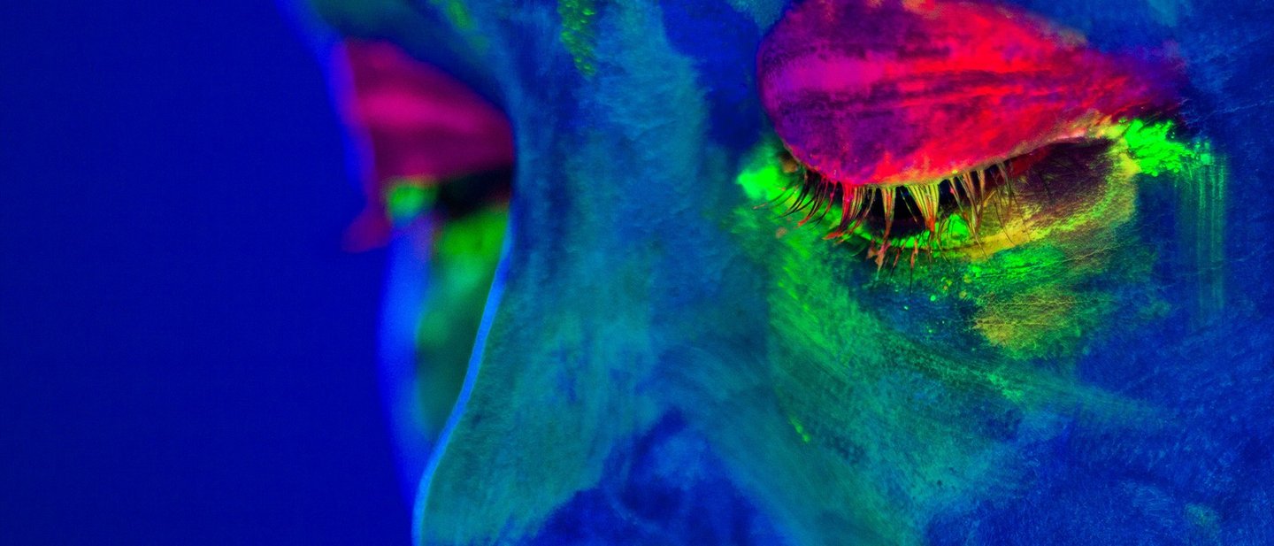 Portrait painted with fluorescent makeup that glows under the ultraviolet light. UV light is one of the security features for securing documents.