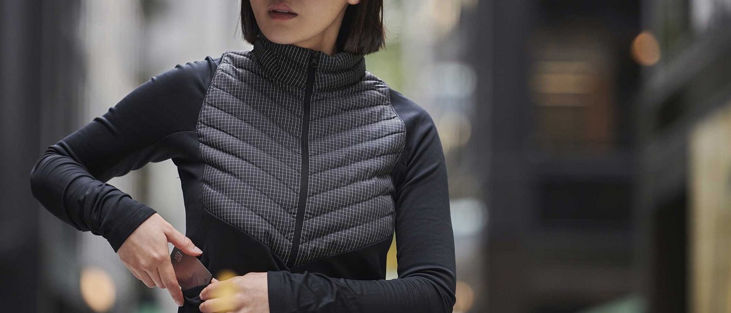 Sporty dressed woman puts metal credit card in her jacket pocket