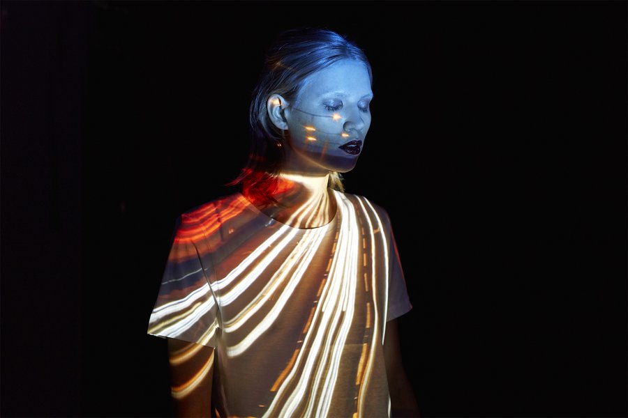 Woman with street light tracks on her top and her face