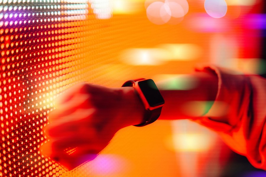 Women holds her smartwatch against a digital wall