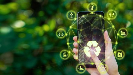 Digital composite image of person using smartphone with green recycling icons