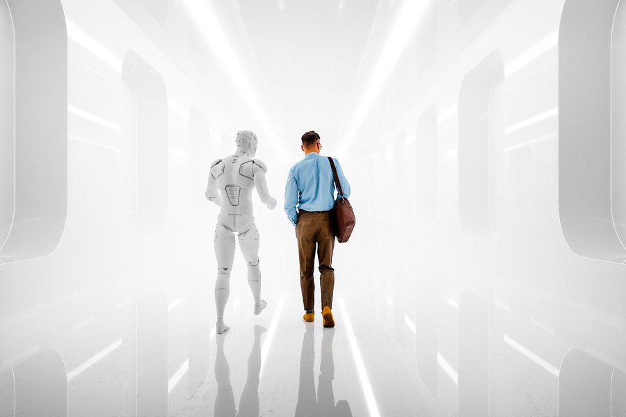 A man in business attire walks alongside a humanoid robot down a brightly lit, futuristic corridor.