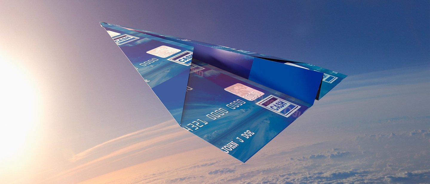 Credit card folded into paper airplane in atmosphere symbolizes contactless payment technology