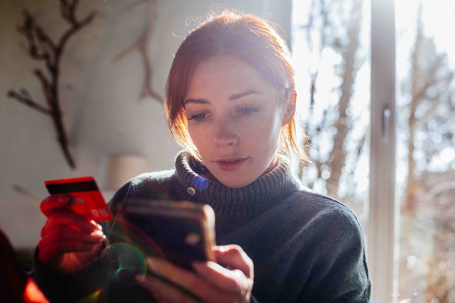 Woman shopping online with credit card using mobile phone.