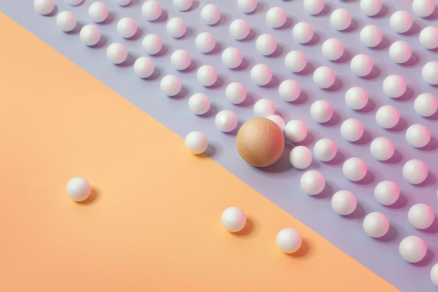 One bigger scale sphere trying to break into an orderly arranged rows of sphere on another side symbolizes how traditional banks have to collaborate with Fintechs.