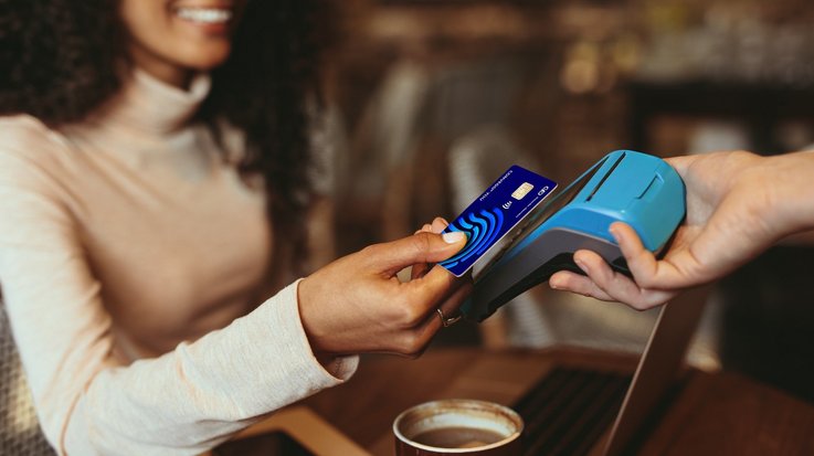 A woman pays for a coffee contactless with her credit card