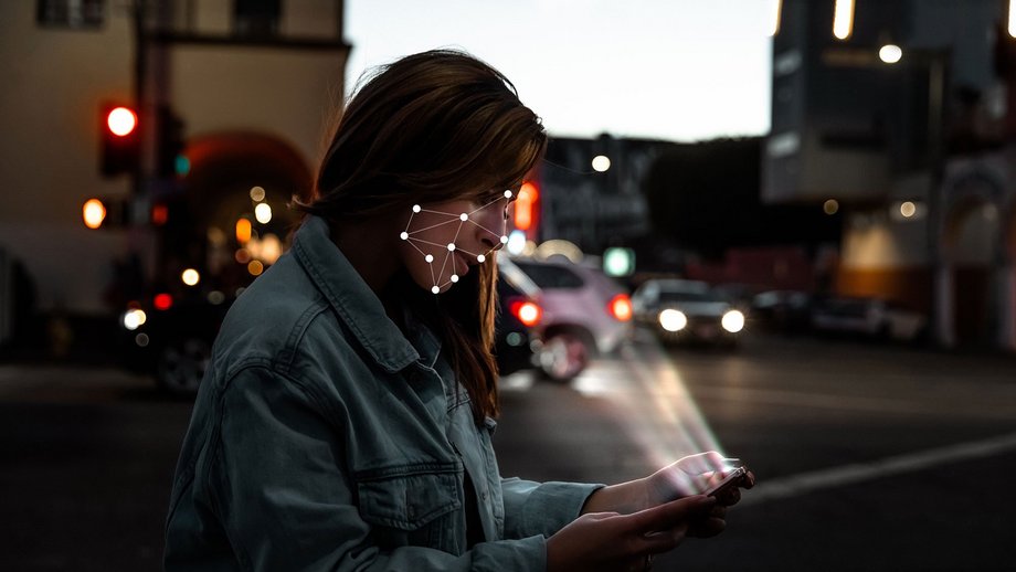 A woman using the face recognition of her smartphone