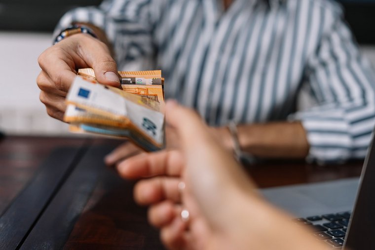 A young woman is paying with european banknotes