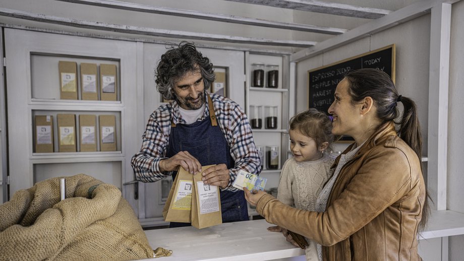 A mother and her child pay with euro banknotes in a shop.