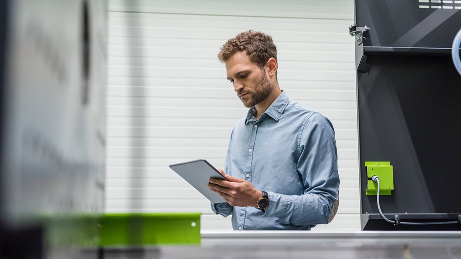 Businessman in a high-tech company, controlling manufacturing machines using a digital tablet