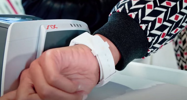 Close-up of a hand with a Swatch Pay while paying