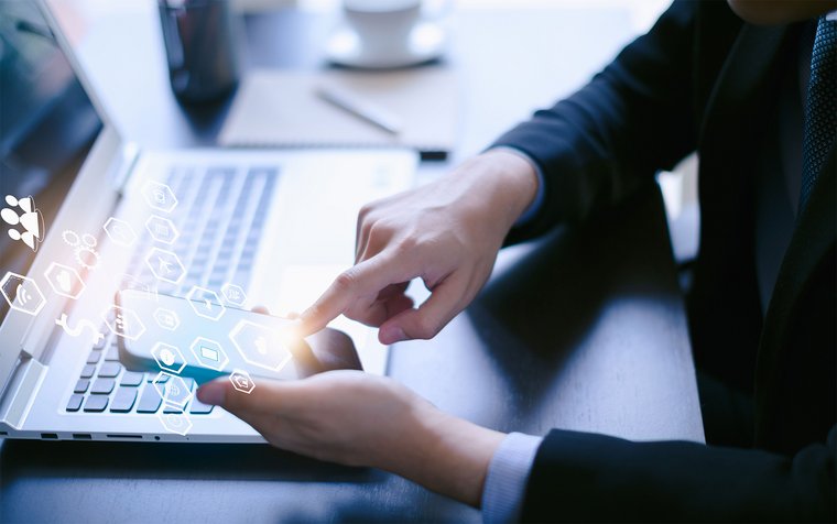 Close up of a man at the mobile and laptop