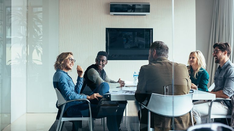 A diverse group of people having a conversation in a meeting room
