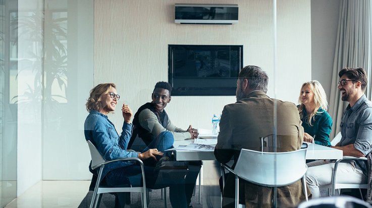 A diverse group of people having a conversation in a meeting room