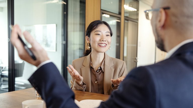 A woman and a man having a conversation in a meeting room